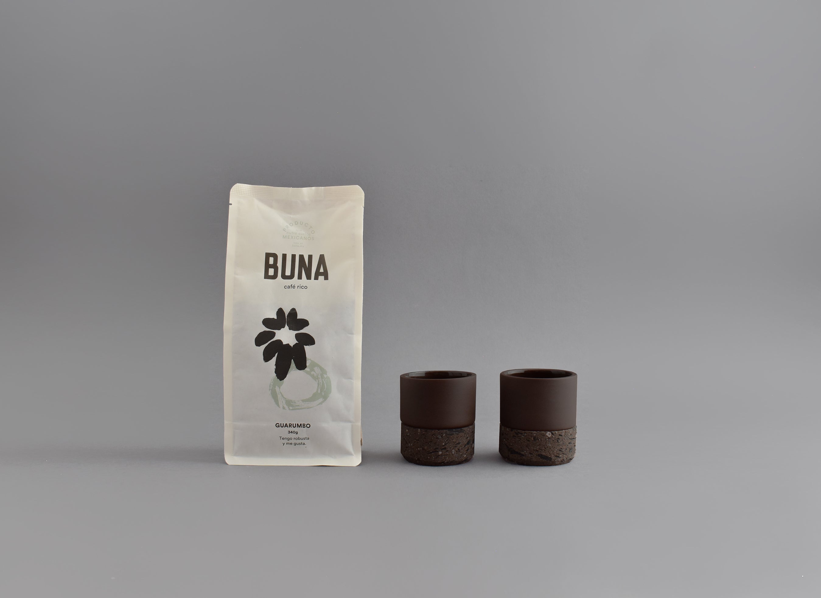 Dos vasos de cerámica café para espresso junto a una bolsa de café Buna